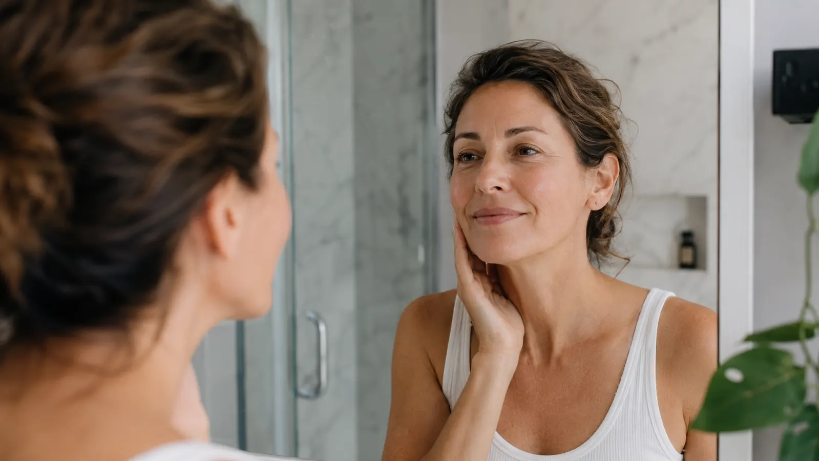Woman waking up and looking in a mirror with smooth skin and no visible sleep crease