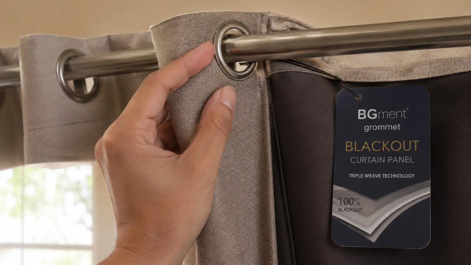 Close-up of a hand pulling a grommet curtain ring along a curtain rod, showing the fabric weight and blackout lining
